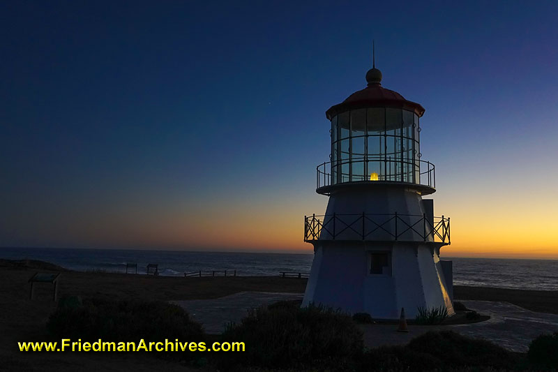 Lighthouse,sunset,sunrise,dusk,dawn,orange,blue,shadow,short,maritime,ocean,shore,